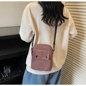Lifestyle shot of a dusty rose canvas crossbody bag with adjustable black shoulder strap