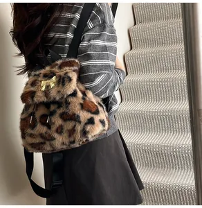 Detailed close-up of leopard print plush backpack featuring a golden bow metal buckle