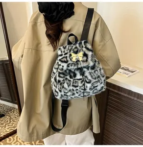 Detail of leopard print faux fur backpack with golden bow clasp on autumn trench coat