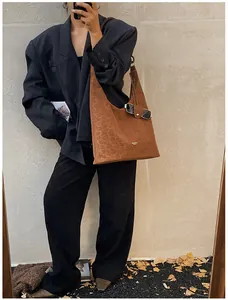 Detail of suede leopard print tote bag with wide shoulder strap in autumn aesthetic setting