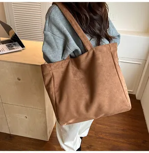 Close-up of caramel suede tote bag featuring reinforced stitching and matte finish