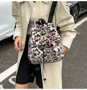 Detail view of leopard print plush backpack with gold bow buckle and drawstring closure
