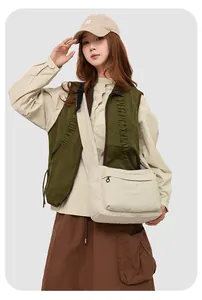 Détail du grand sac bandoulière en nylon crème avec poche extérieure zippée pratique