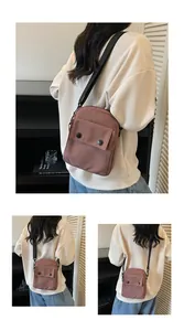 Detail view of pink canvas shoulder bag showing front flap pocket and black strap