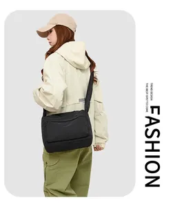 Vue détaillée du sac bandoulière en nylon noir avec poche zippée porté par un mannequin