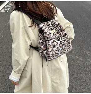 Detailed macro view of the soft leopard print plush texture and gold bow buckle on backpack