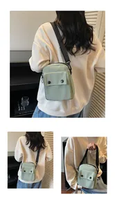 Detailed view of mint green canvas crossbody bag with decorative black snap buttons