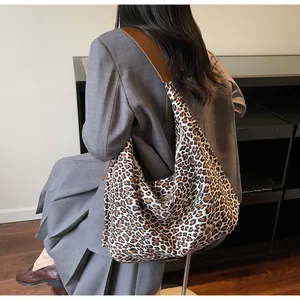 Detailed shoulder view of a large leopard print tote bag with brown leather strap