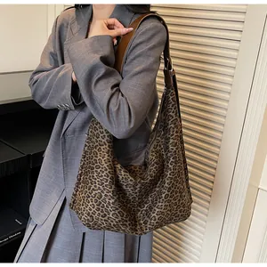 Detail of leopard print hobo bag showing wide brown leather strap and zip closure