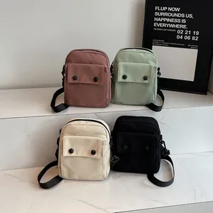 Minimalist canvas shoulder bags in four colors with double button flap on marble steps
