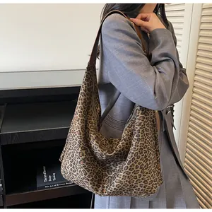 Leopard print tote bag with brown leather straps shown on shoulder for daily commute