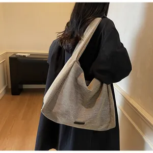 Detailed texture of a grey large capacity canvas hobo tote bag shown on model