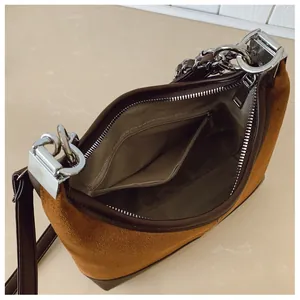 Dettaglio dello spazioso scomparto interno e della tasca con zip della borsa in pelle scamosciata