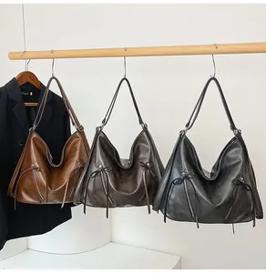 Detailansicht von drei Vintage-Hobo-Taschen mit seitlichen Schleifen und Ledertextur