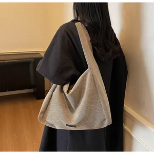 Detailed texture of khaki woven tote bag showing large capacity and minimalist wide strap