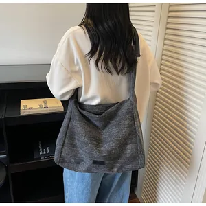 Close-up of the large grey fabric tote bag shown on a model for daily style