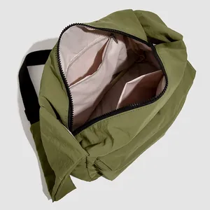 Sac bandoulière en nylon vert olive montrant l'intérieur spacieux et les poches