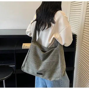 Detailed back view of a large grey canvas tote bag with minimalist logo on shoulder