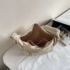 Large beige nylon shoulder bag with spacious interior compartments and side zipper