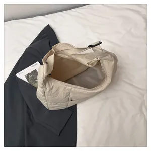 Detail view of large cream puffy tote bag with wide interior and adjustable strap