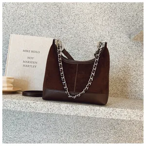 Dettagli in pelle scamosciata marrone scuro e catena metallica argento in stile vintage