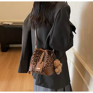 Leopard print bucket bag with brown leather trim and a cute plush bear pendant accessory