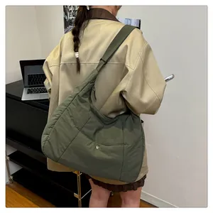 Olive green quilted puffer tote bag with adjustable wide strap and metallic button detail