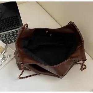 Spacious dark brown tote bag with metal chain strap and magnetic snap closure detail