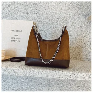 Dettaglio della borsa hobo con trame a contrasto in camoscio marrone e pelle