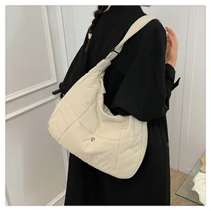 Detail view of large cream-white crossbody moon bag with adjustable strap and front pocket