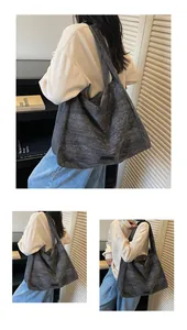 Detail of dark grey canvas tote bag showing textured fabric and small leather patch