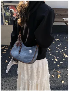 Dettaglio della borsa hobo con profili a contrasto e nastro a righe in stile street outdoor