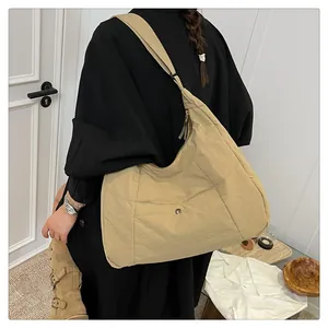 Detail of khaki tote bag with stitched texture and metal snap button on front pocket