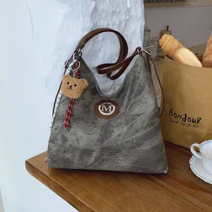 Sac fourre-tout rétro en denim gris avec anses en cuir marron et pendentif ours en peluche