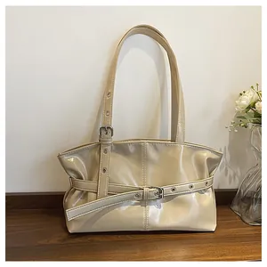 Detail of cream faux leather shoulder bag with glossy texture and metal buckle accents