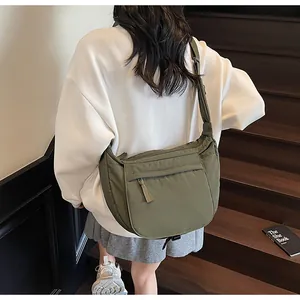 Detail view of olive green nylon crescent bag with adjustable strap and zip pocket