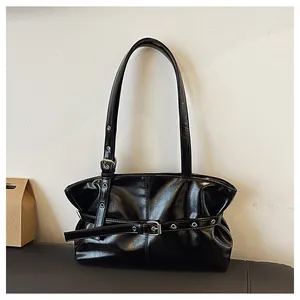 Detail of glossy black PU leather texture and silver metal eyelets on shoulder bag