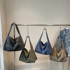 Minimalist large canvas tote bags in four neutral colors hanging on a modern metal rack