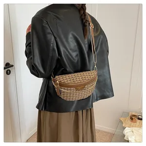 Detail of moon-shaped crossbody bag with houndstooth pattern and wide strap on model