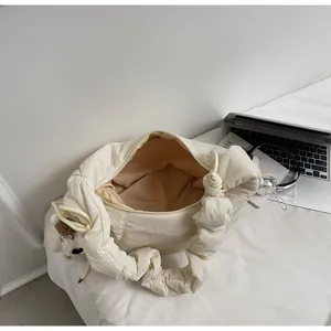 Top view of cream quilted cloud bag showing spacious interior and puppy charm detail
