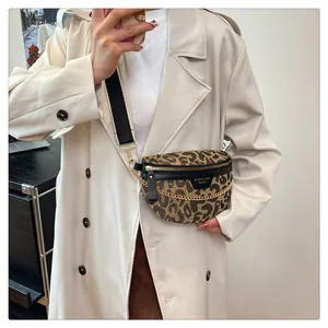 Detail of leopard print crossbody bag with gold chain and wide strap on trench coat