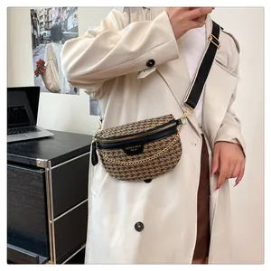 Close-up of houndstooth tweed crossbody bag with gold chain and wide nylon strap