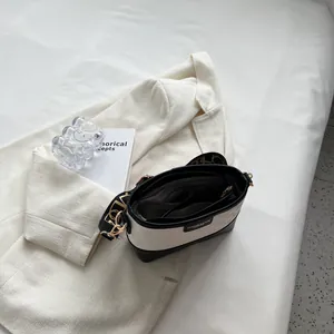 Chic black and white bucket bag with a wide lettered strap and multiple compartments