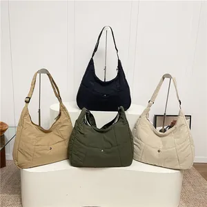 Quilted nylon hobo bags in four colors displayed on a minimalist white stand