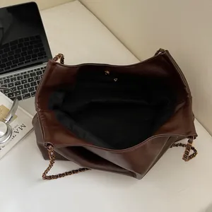 Minimalist large brown tote bag with gold chain strap shown from an overhead perspective
