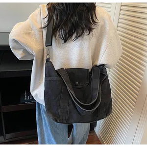 Detail view of large denim tote bag with adjustable shoulder strap and side pocket