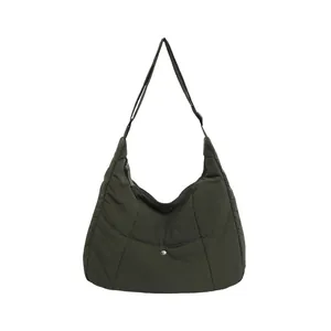 Olive green puffer tote bag featuring quilted crescent shape and adjustable strap