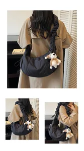Detail of black crescent shoulder bag featuring quilted fabric and ruched shoulder strap