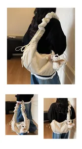 Detail of quilted cloud bag with ruffled shoulder strap and cute teddy bear pendant