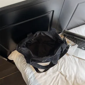 Black minimalist denim tote bag with spacious interior and adjustable shoulder strap